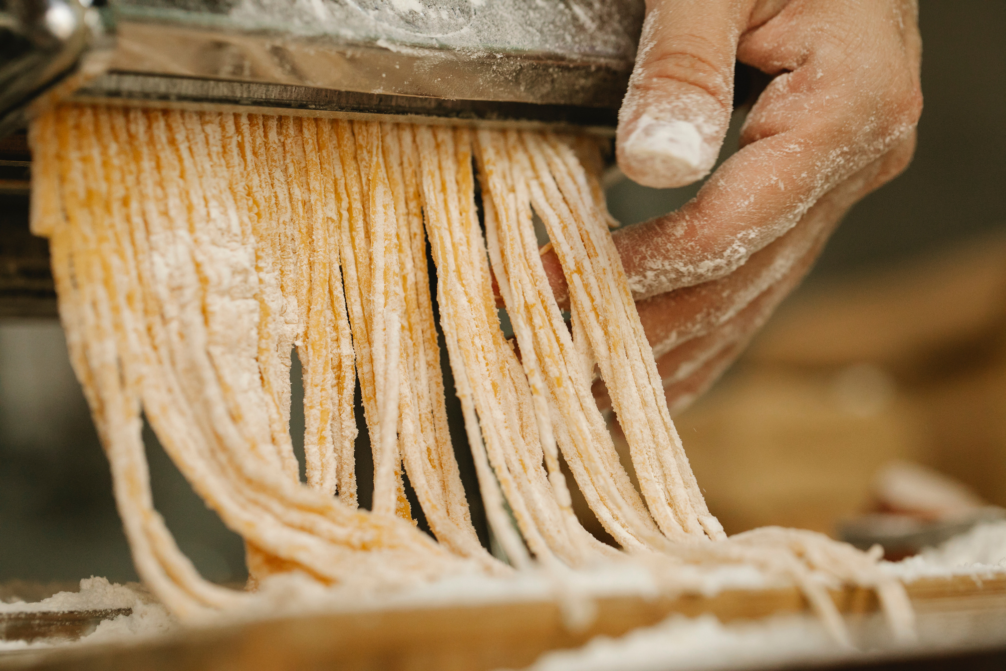 Crop cook preparing noodles with pasta maker